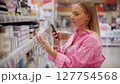 Customer using smartphone scanning products in supermarket 127754568