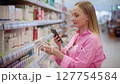 Customer using smartphone scanning product in pharmacy or supermarket 127754584