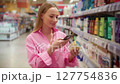Customer scanning product barcode with smartphone in supermarket 127754836