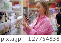 Woman using smartphone to scan product in store 127754838