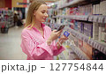Woman choosing medicine in pharmacy scanning products with smartphone 127754844