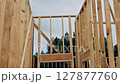Workers are assembling beams frame framework of new building with construction site. 127877760