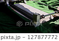 Funeral casket is prominently placed on green velvet surface, ready for burial ceremony in cemetery setting. 127877772