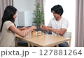 Two Asian teenage boys and girls playing wooden games at home during school break. 127881264