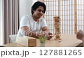 Two Asian teenage boys and girls playing wooden games at home during school break. 127881265