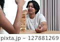 Two Asian teenage boys and girls playing wooden games at home during school break. 127881269