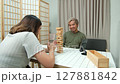 Middle-aged couple relaxing and playing wooden game together at home. 127881842