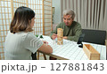 Middle-aged couple relaxing and playing wooden game together at home. 127881843