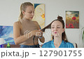 4K. The bride is getting ready for the wedding. A girl gets her hair done 127901755