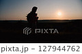 Silhouette of a female traveler admiring the sunset.  127944762