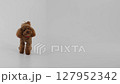A Cute Brown Puppy Resting on a Clean White Background, radiating joy with its fluffy fur 127952342