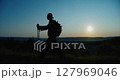 Silhouette of a male traveler admiring the sunset. 127969046
