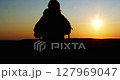 Silhouette of a female traveler admiring the sunset.  127969047