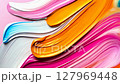 Pink, orange, light blue and white acrylic paint mixing and swirling together 127969448