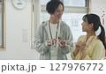 オフィスで会話する若いビジネスパーソン 127976772