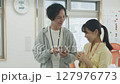 オフィスで会話する若いビジネスパーソン 127976773