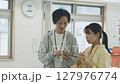 オフィスで会話する若いビジネスパーソン 127976774