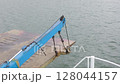 Close up of crane connect with ramp on cargo vessel heading towards to the port 128044157