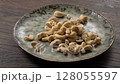 Cashews spilling onto plate ready for snack time. 128055597