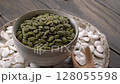 Pumpkin seeds rotate close up on rustic wooden table. 128055598
