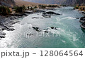 Aerial shot flying a river flowing in mountain. Amazing dynamic drone shot. Beautiful blue river flowing from the Mountains surrounding. Turbulent mountain river with rapids 128064564