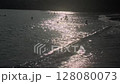 Swimming in the Sea at Sunset with Waves on Shore 128080073