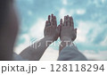 Newlywed couple holds hands with rings up to the sky 128118294