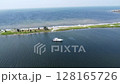 Serene views of boats on the water, with summer sun warming the beach and the vast ocean horizon 128165726