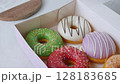 Donuts with colorful icing glazed designs on a white background. 128183685