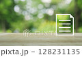 Document flat icon on wooden table over blur green tree in park, Technology internet online concept 128231135
