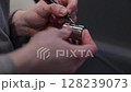 Close-up of a craftsman using a handheld rotary tool to clean or polish internal threads of a metal part in a workshop. Concept of precision, craftsmanship, and manual work 128239073