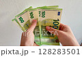 Hands Counting Money Closeup of 100 euro on a white background. Bills Being Counted 128283501