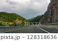 Bulgaria, Kalotina, 5.07.2025. Summer road trip, hilly terrain, first-person view from a moving car on a highway, summer natural landscape, car ride on the road. 128318636