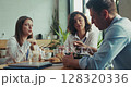 Three caucasian intern teammates enjoy lunch together in slow motion at bright sunny office cafeteria 128320336