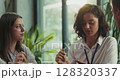 Three caucasian intern teammates enjoy lunch together in slow motion at bright sunny office cafeteria 128320337