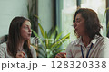 Three caucasian intern teammates enjoy lunch together in slow motion at bright sunny office cafeteria 128320338