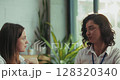 Three caucasian intern teammates enjoy lunch together in slow motion at bright sunny office cafeteria 128320340