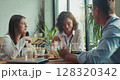 Three caucasian intern teammates enjoy lunch together in slow motion at bright sunny office cafeteria 128320342