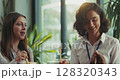 Three caucasian intern teammates enjoy lunch together in slow motion at bright sunny office cafeteria 128320343