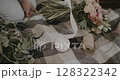 woman decorates bouquet as gift. Floristry creating flower 128322342