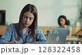 Female employee prepares pitch with laptop and notebook during lunch break in close up slow motion pan  128322458