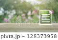 Document flat icon on wooden table over blur pink flower and tree in park, Technology internet online concept 128373958