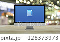 Document flat icon on desktop modern computer monitor screen on wooden table over blur light and shadow of shopping mall, Technology internet online concept 128373973
