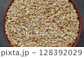 Rotating Bowl Filled with Dry Rolled Oats Top View 128392029