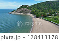 Peaceful Thai beach below tropical green mountain slope 128413178