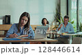 Female employee prepares pitch with laptop and notebook during lunch break in close up slow motion pan  128446614