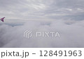 Clouds in sky. Airplane flight in white soft cloud. Passenger plane landing, looking from jet window 128491963