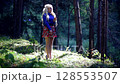 Blonde woman in short skirt sings calm song in summer forest sunlight 128553507