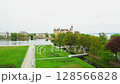 Aerial shot circles Schwerin Castle, unveiling its majestic towers, shimmering lakes, and lush gardens in breathtaking detail. 128566828
