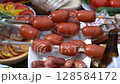Meat on skewers and sausages are fried on the grill.Spinning barbecue for outdoor kitchen. Street restaurant. 128584172